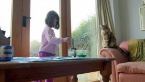Autistisches Mädchen mit Schwierigkeiten malt in Gesellschaft ihrer Katze