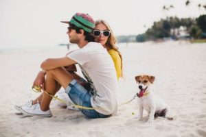 Paar am Strand genießt Augenblick mit Hund