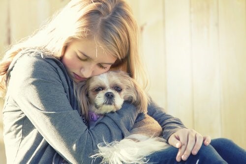Depressionen bei Hunden - Mädchen umarmt Hund